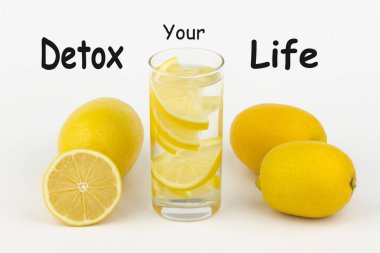 Detoks Your Life yazıldı beyaz arka plan ve limon dilimleri ile su.