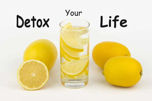 Detoks Your Life yazıldı beyaz arka plan ve limon dilimleri ile su.