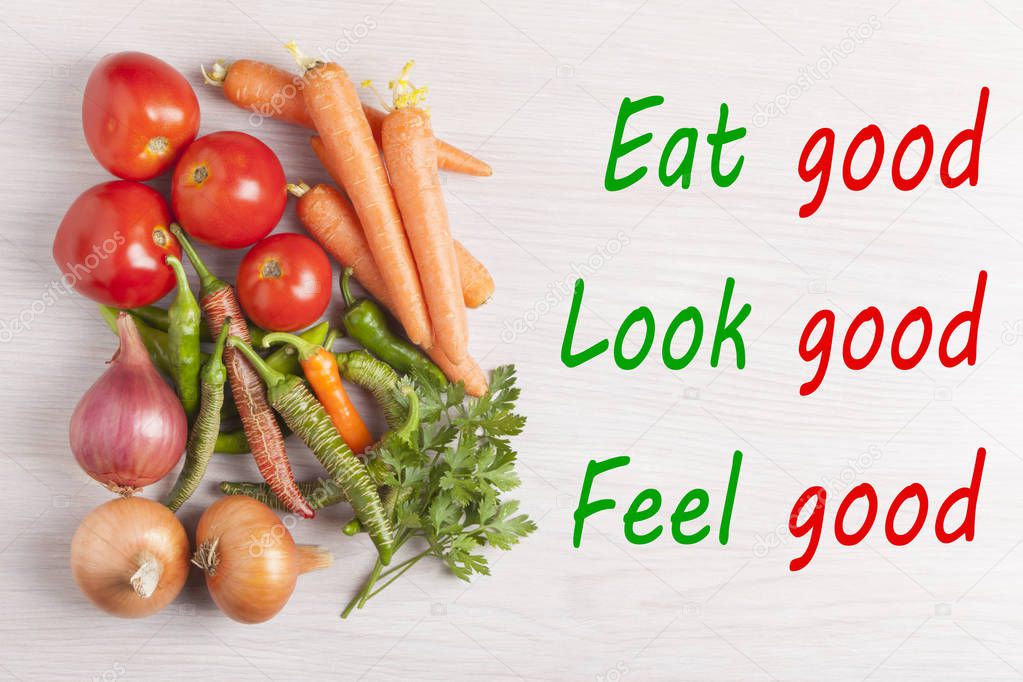 Eat good, Look good, Feel good written on wooden desk and group vegetables. Top view.