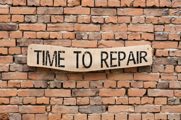 レンガ壁の背景に木製の看板に書かれた修理時間 — ストック写真