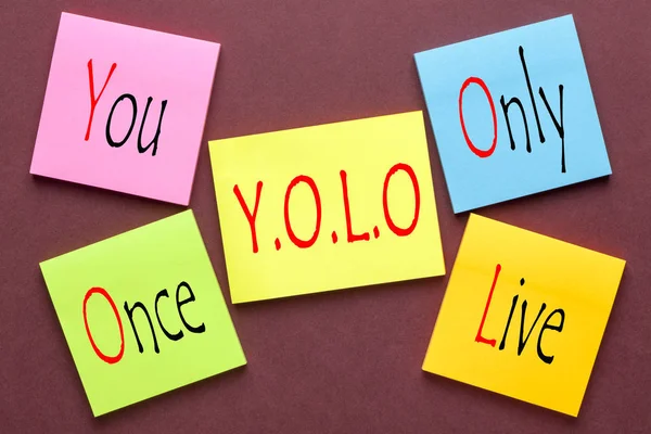 You Only Live Once written on color notes. YOLO Acronym.