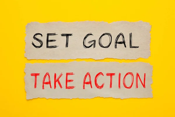 SET GOAL TAKE ACTION written on old paper on yellow background. Business concept.