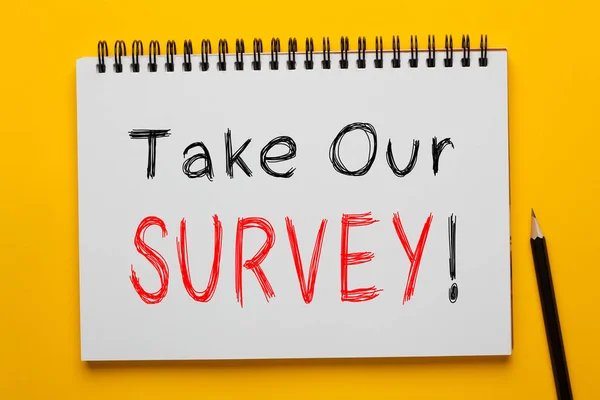 Take Our Survey! written on notepad with pencil on yellow background. Business concept.