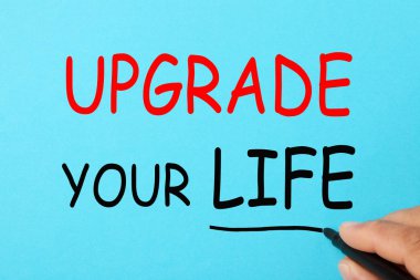Upgrade Your Life mavi bir arka plan üzerinde yazma el. İş kavramı.