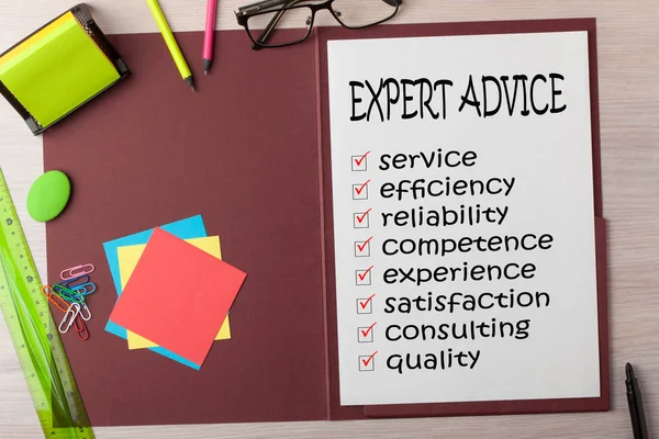 EXPERT ADVICE with checklist written on paper sheet in presentation folder and various stationery. Business concept.