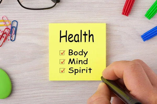 Health Body Mind Spirit handwriting on note with marker pen and glasses. Health concept.