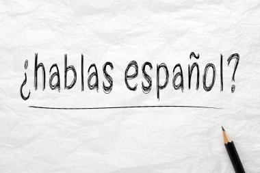 Hablas Espanol soru? İspanyolca biliyor musun? kalemle buruşuk çizgili kağıt üzerinde yazılı. Öğrenme diller konsepti.