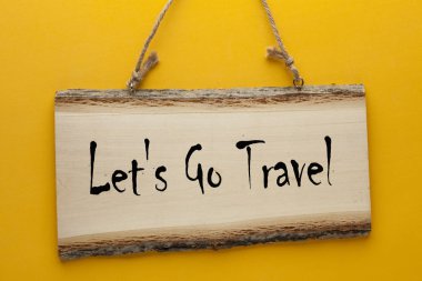 Seyahat metin ahşap işareti bir ip üzerinde sarı arka plan asılı ile gidelim. Motivasyon yazıt