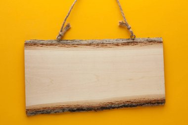 Boş tahta işareti ip üzerinde sarı bir arka plan ile. Metniniz için boş yer
