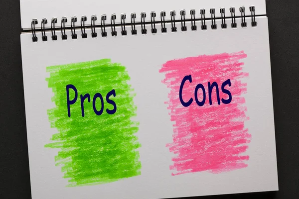 Pros and Cons on painted sketchbook in red and green. Business concept.