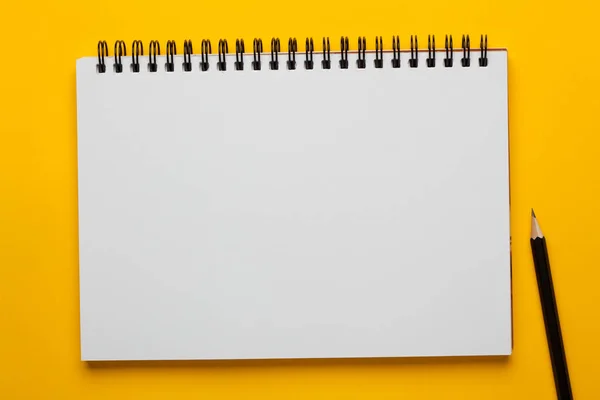 在黄色背景上用铅笔打开笔记本 经营理念 — 图库照片