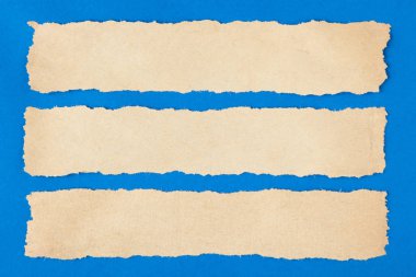 Kopya alanı mavi zemin üzerine kağıt parçası yırtılmış. Yakın çekim. Metin için yer.