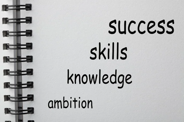 Success , knowledge, skills and ambition words in the shape of a staircase on notebook. Business concept.
