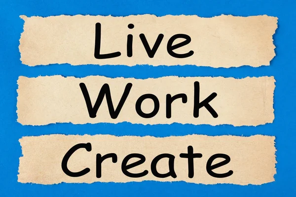 Live Work Create written in old torn paper on blue background. Business concept