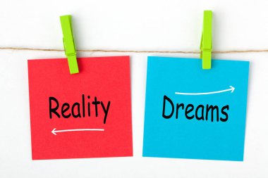 Rüyalar gerçek kelime renk notları ahşap çimdik üzerinde yazılı karşı. İş kavramı