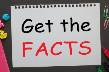 Defter kağıt ve ofis malzemeleri siyah arka plan üzerine yazılı gerçekleri öğrenin. İş kavramı.