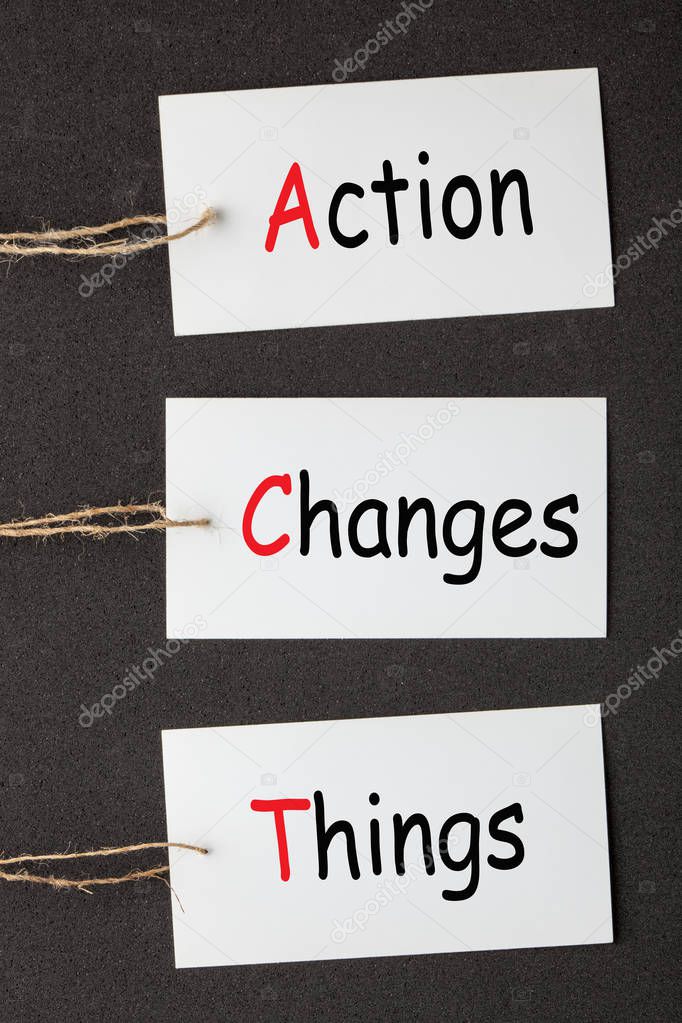 Action Changes Things (ACT) acronym written on paper labels set on black background. Business concept