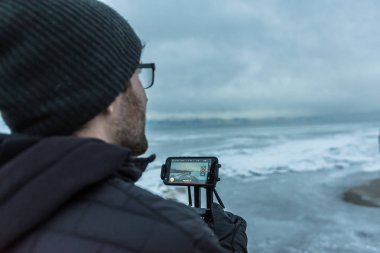 Adam donmuş göl üzerinde siyah drone helikopter uçar