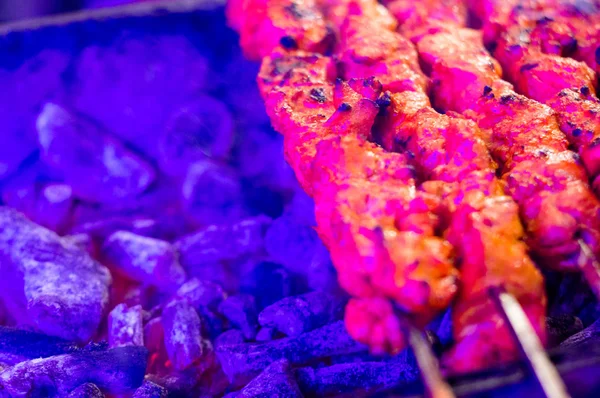 Paneer y carne tikka tostado en pinchos bajo luz de color — Foto de Stock