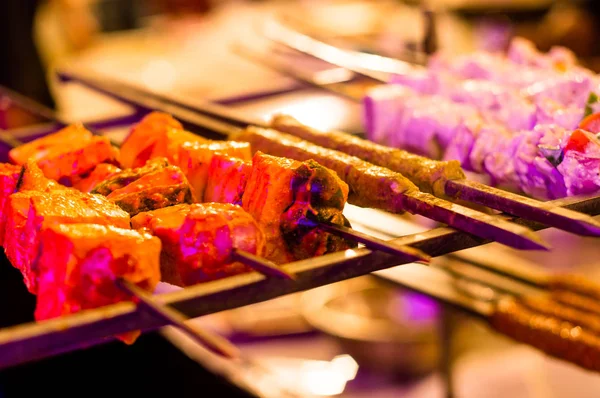 Paneer y carne tikka tostado en pinchos bajo luz de color — Foto de Stock