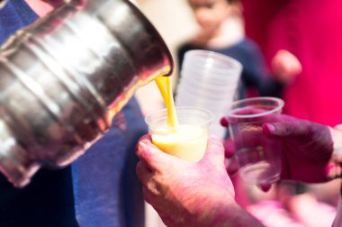 Thandai çelik bir balonun üzerinden tek kullanımlık bir fincan içine dökme