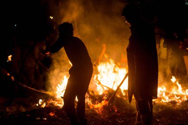 Siluet insanların önünde ateş Holi Lohri Festivali için kavurma tahıl 