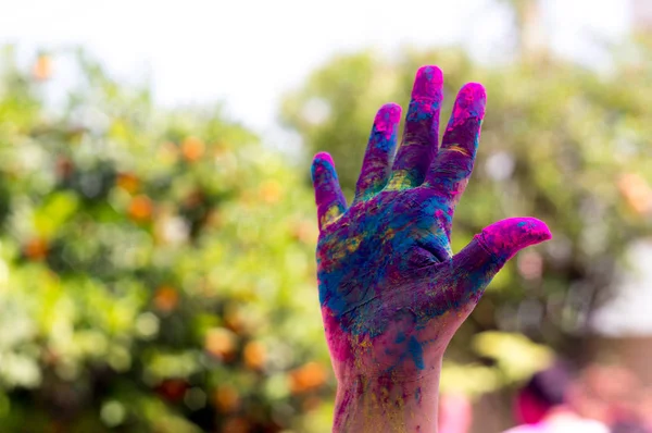 Colorful hand shot against a blurred background during the hindu festival of Holi — Stock Photo, Image