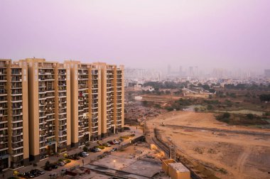 Gurgaon gökdelenler çorak arazi ve bir köy üzerinde bakıyor