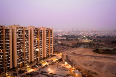 Gurgaon gökdelenler çorak arazi ve bir köy üzerinde bakıyor
