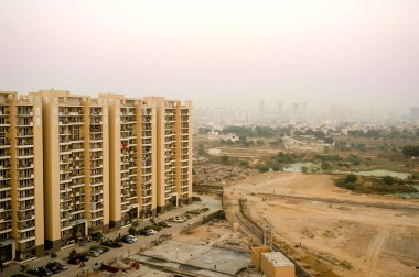 Gurgaon gökdelenler çorak arazi ve bir köy üzerinde bakıyor