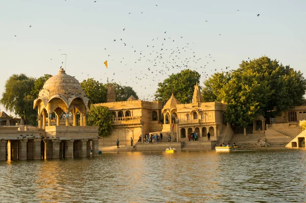 Cúpulas de arenito chattri com passos no lago gadi sagar em jaisalmer ao entardecer — Fotografia de Stock