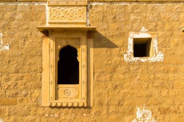 Traditional arched window in a sandstone stone wall in kumbalgarh Jaisalmer clipart