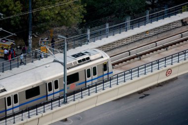 Aerial shot of metro train on an overhead metro track clipart
