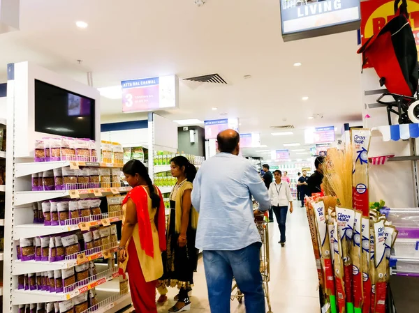 Vrouwen en mannen shoppers verplaatsen zich rond een warenhuis — Stockfoto