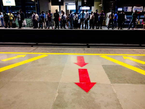 Arrows on the ground point the exit and entry process for the metro as crowds look on — Stock Photo, Image