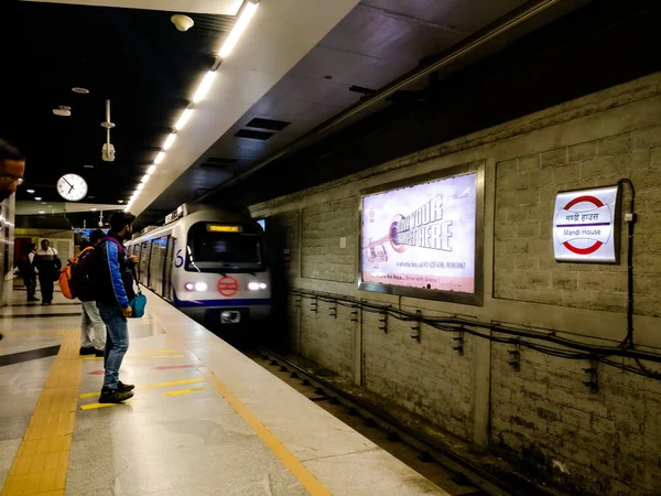 Motion blur of metro train arriving at a metro station while people watch — Stock Photo, Image