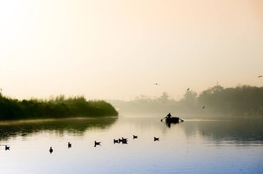 Altın güneş, sis ve mavi su ile yamuna ghat erken sabah