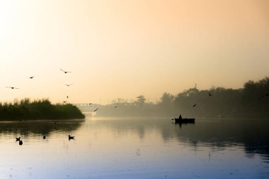 Altın güneş, sis ve mavi su ile yamuna ghat erken sabah