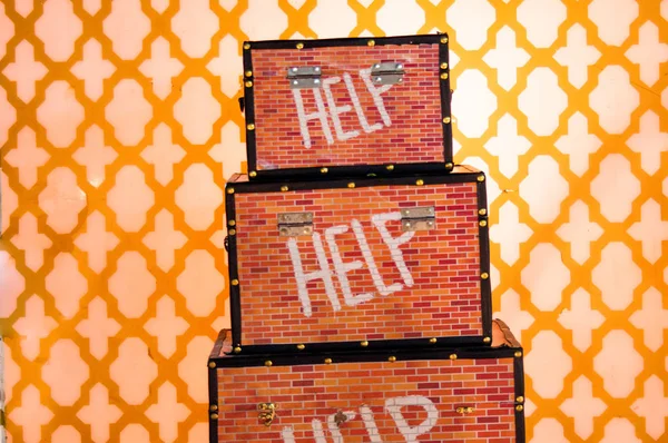 Colorful aid boxes placed above one another on a yellow patterned background