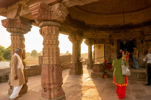 Pessoas que oferecem orações em um templo hindu durante o pôr do sol — Fotografia de Stock