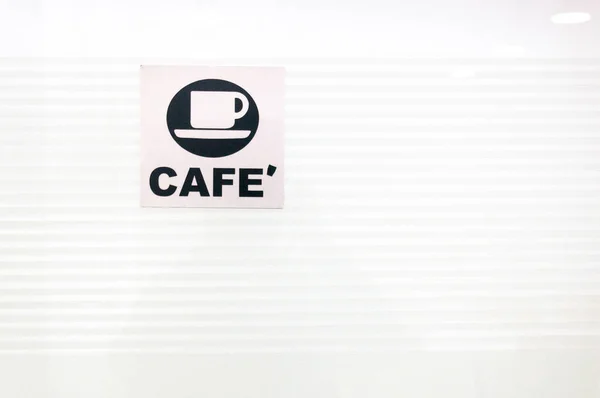 Cafe sign in black and white with a coffee cup on a white glass background