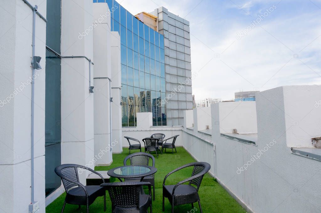 Outdoor seating space in a building with artificial grass and seats