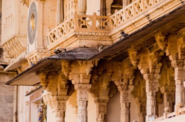 Kemerli, balkonlu ve pencereleri olan udaipur sarayının oyma kumtaşı dış duvarları