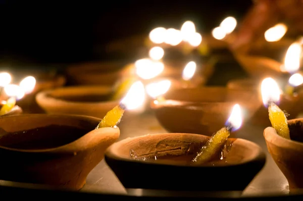 Makroaufnahmen von Diyas, die von Hand oder Kerze für das hinduistische religiöse Fest Diwali angezündet werden. — Stockfoto