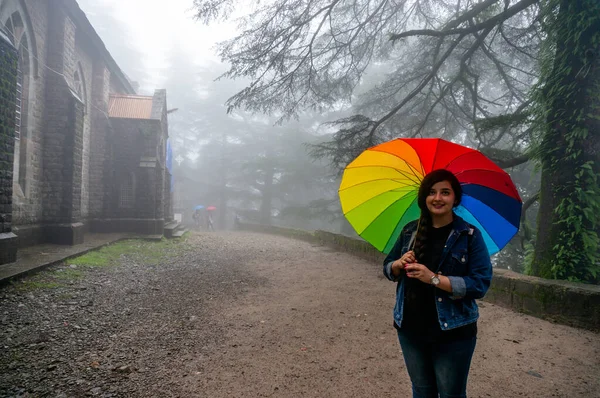 Joven chica india de pie frente a una niebla San Juan de la iglesia salvaje un famoso monumento público —  Fotos de Stock