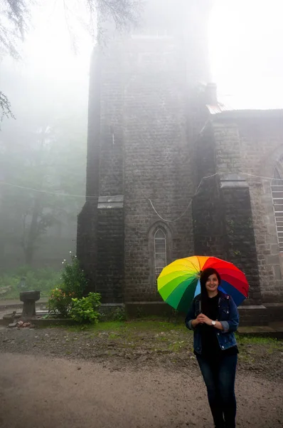 Joven chica india de pie frente a una niebla San Juan de la iglesia salvaje un famoso monumento público — Foto de Stock