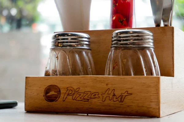Wooden salt pepper oregano and chili flakes shaker and tissue holder at Pizza hut in india — Stock Photo, Image