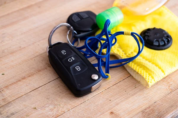 Car keys, sanitizer, yellow mask and more placed on a wooden board with the new essentials for going outdoor with the coronavirus covid 19