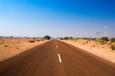 Hindistan 'da her iki tarafında çorak çöl bulunan dar yol.