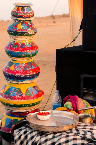 Foto de la noche mostrando los accesorios como ollas de barro, ollas de barro, platos, hervidor de agua, micrófonos y más como accesorios para bailes tradicionales rajasthani para el entretenimiento del visitante en un campamento del desierto — Foto de Stock